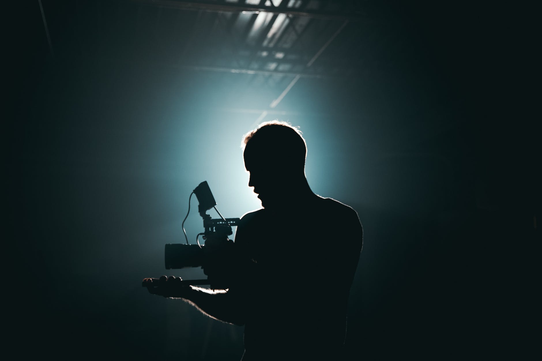 silhouette of man standing in front of microphone